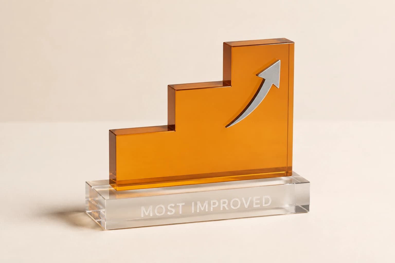 Amber acrylic student award with rising steps and a silver arrow.